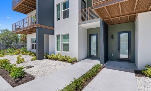 a building with a walkway and plants